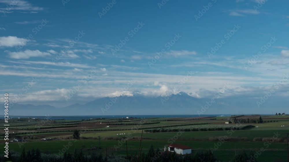 Timelapse view of picturesque landscape with Mount Olympus, forests, farm, fields, countryside against flying clouds in the blue sky, Greece Timelapse view of picturesque landscape with Mount Olympus, forests, farm, fields, countryside against flying clouds in the blue sky, Greece