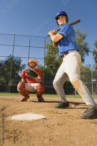 Athletic baseball player ready to hit the shot with catcher in background
