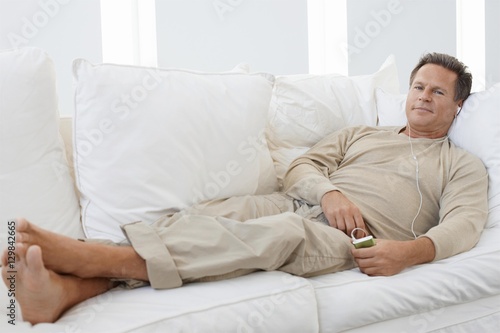 Senior man listening to music while relaxing on the couch