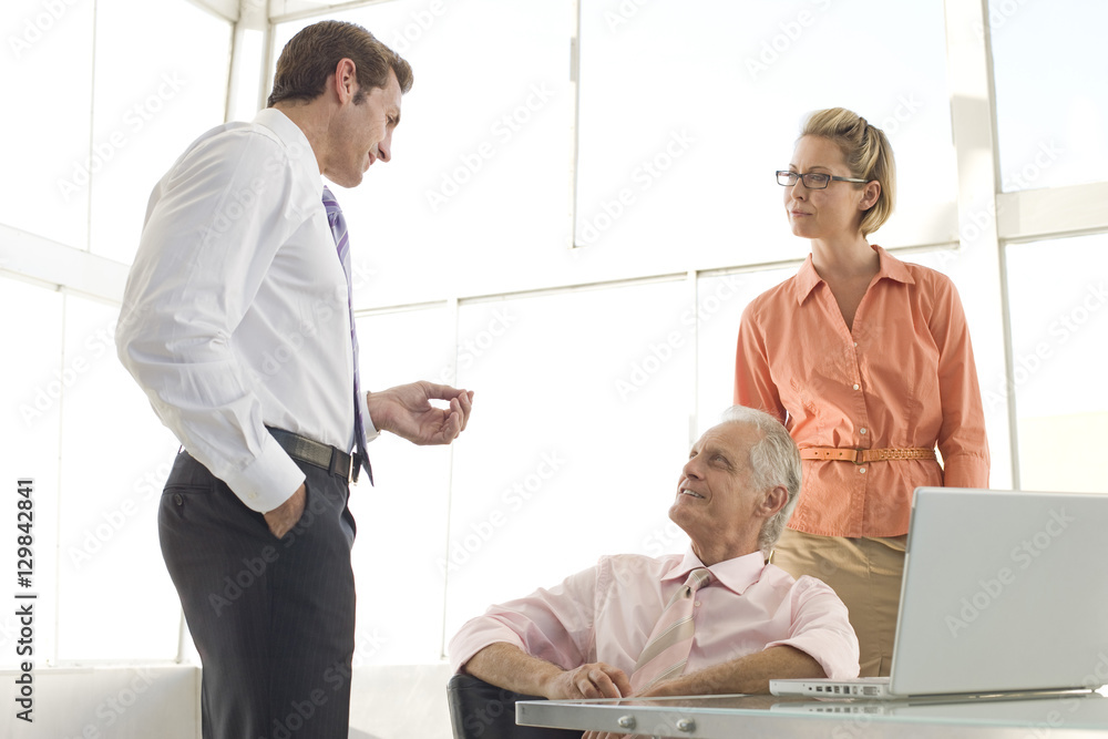 Male executive having discussion with colleagues in meeting room Male executive having discussion with colleagues in meeting room