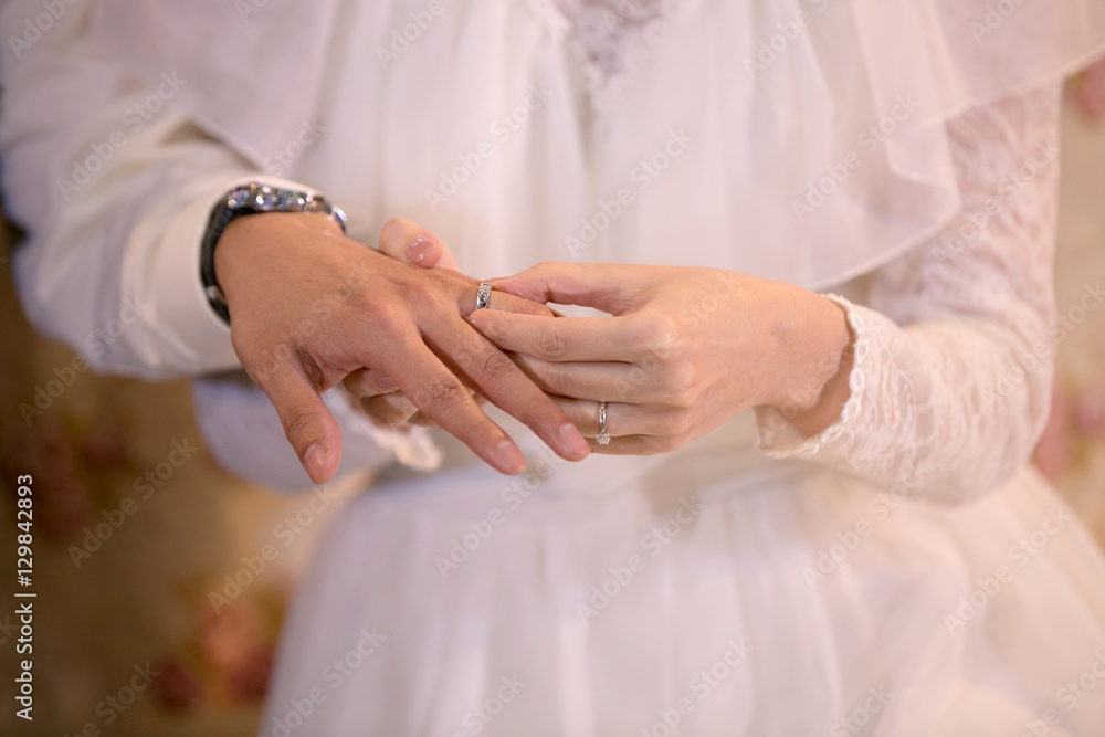 Groom wears wedding ring. Bride wearing wedding ring Groom wears wedding ring. Bride wearing wedding ring