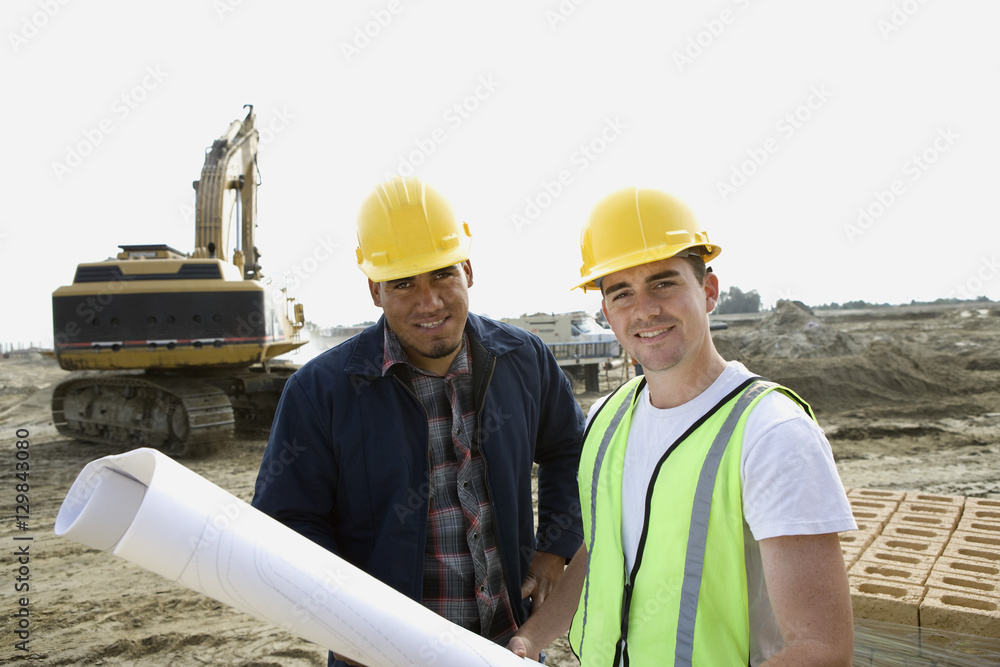 Portrait of architects with blueprint at construction site Portrait of architects with blueprint at construction site