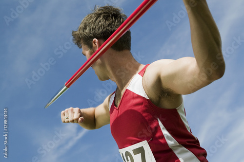 Fotografía Young male athlete about to throw javelin against the sky