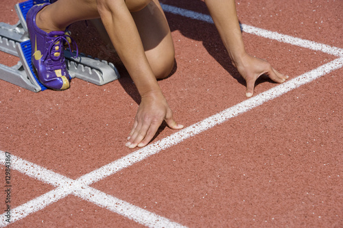 Cropped image of female athlete at starting line ready to race
