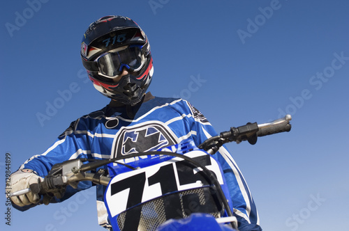 Canvas Print Low angle of male off road motor biker against clear sky