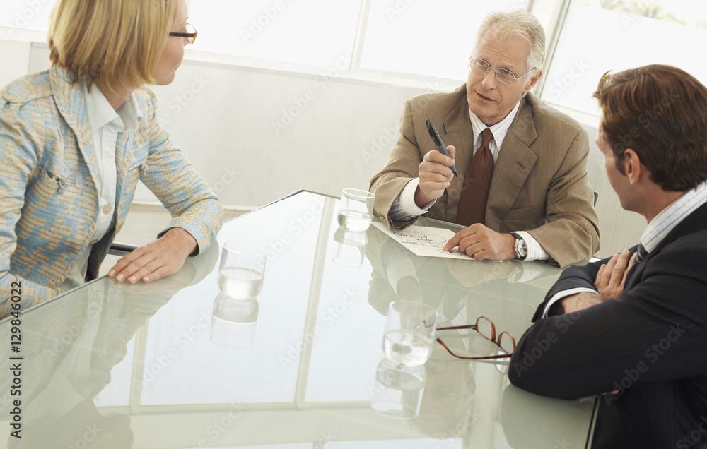 Obraz premium Senior businessman discussing with colleagues in conference room