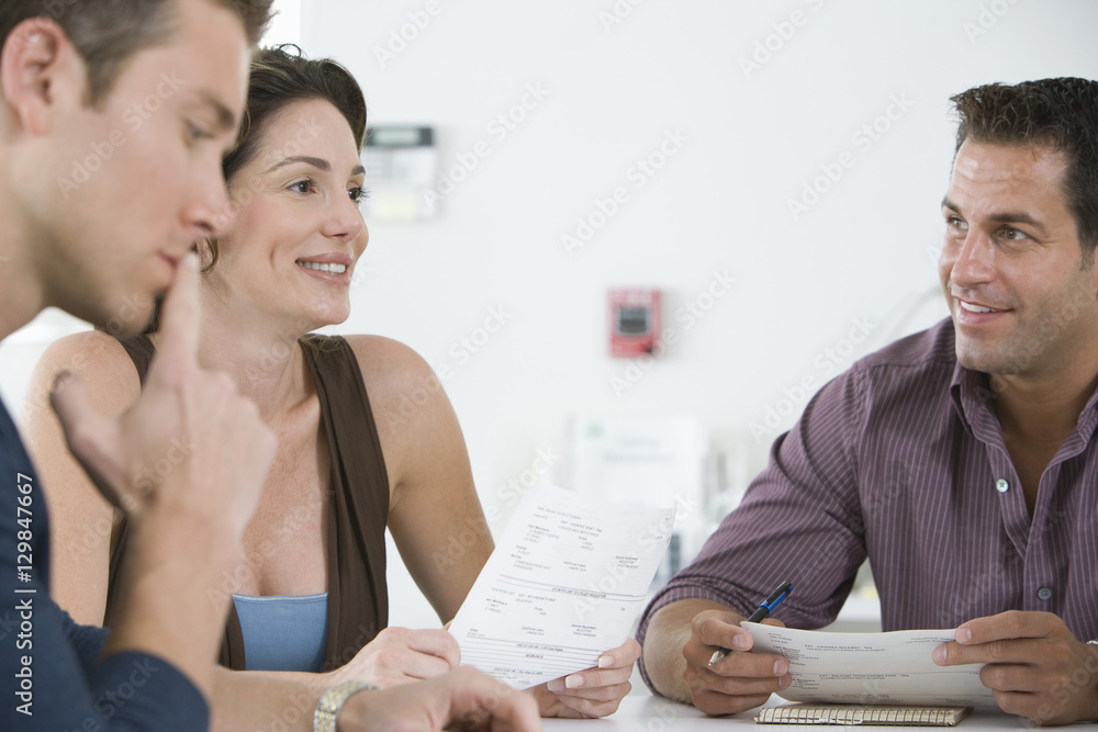 Business people reviewing documents during meeting in conference room Business people reviewing documents during meeting in conference room