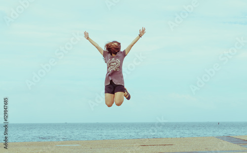 The asian girl jump at the sea on holiday vintage pastel style