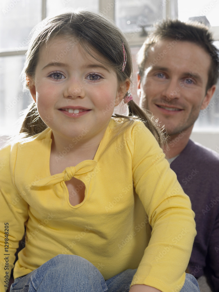Portrait of cute girl with father siting at home