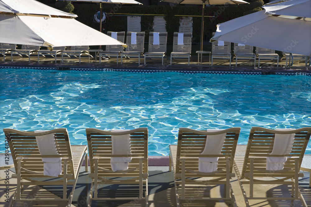 View of swimming pool with lounge chairs and sunshades View of swimming pool with lounge chairs and sunshades