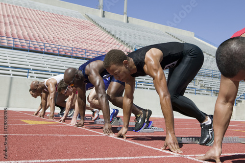 Group of multiracial male athletes lined up at starting line