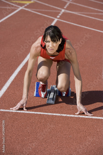 Full length of a Caucasian female runner at starting line