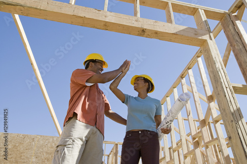 Low angle view of an African American couple at construction site giving high-five