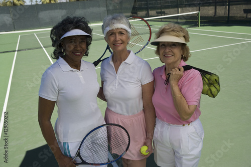 Portrait of diverse senior female friends at tennis court