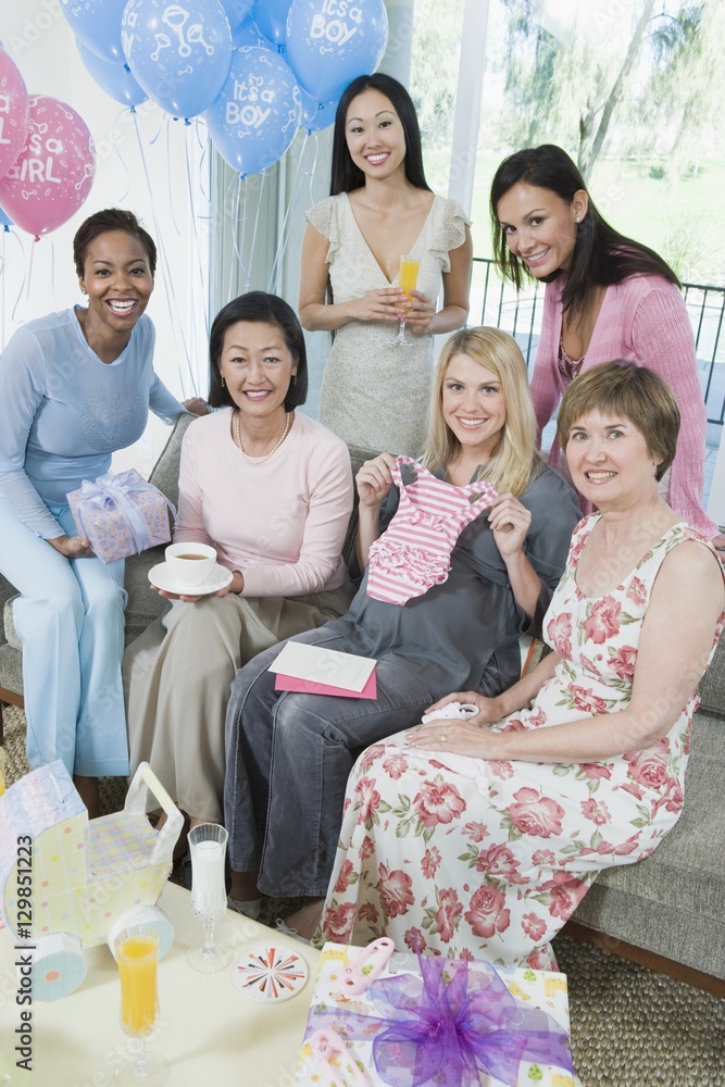 Portrait of happy pregnant woman and female friends at a baby shower