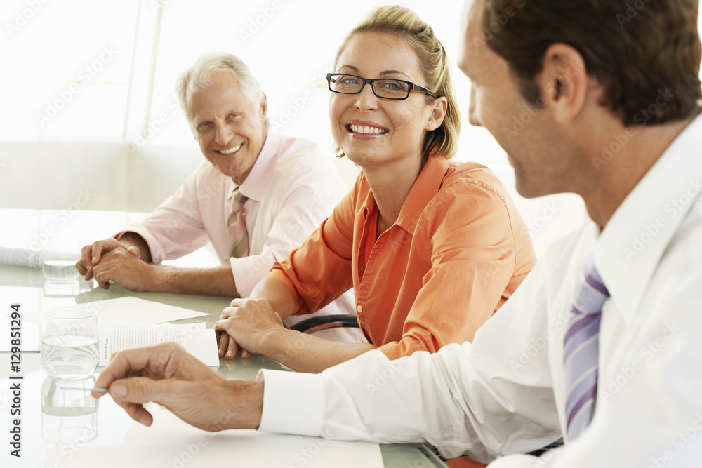 Obraz premium Portrait of happy businesswoman with colleagues in conference room