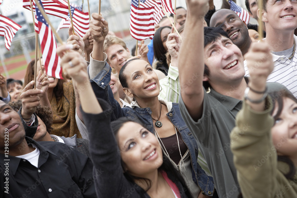 Obraz premium Group of multiethnic people holding up American flags