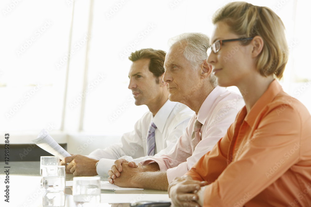 Obraz premium Side view of mature businessman with colleagues in conference room