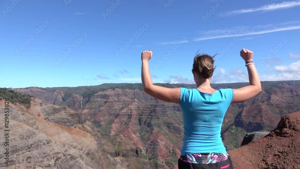 SLOW MOTION: Happy young woman on top of the mountain raising arms proudly SLOW MOTION: Happy young woman on top of the mountain raising arms proudly