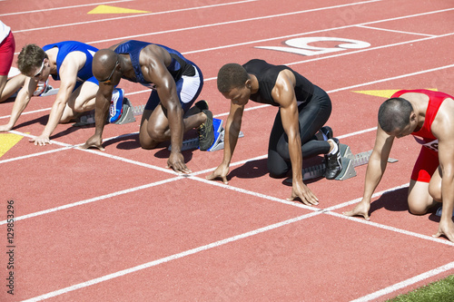 Group of multiethnic male athletics waiting at starting blocks