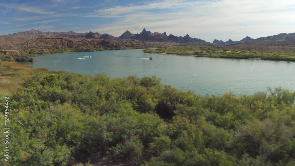 Jetskis speeding on beautiful river with rocky mountains in background Jetskis speeding on beautiful river with rocky mountains in background