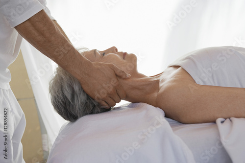 Side view of a senior woman receiving massage at spa