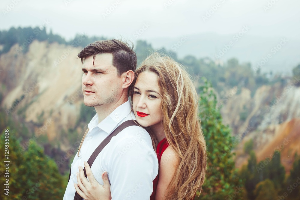 the couple stands in the mountains