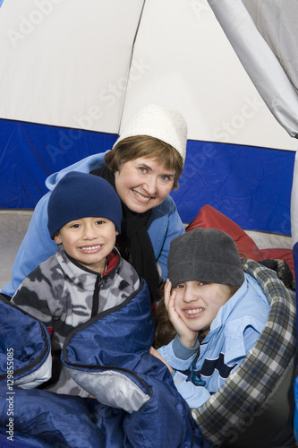 Portrait of happy senior woman with grandchildren inside tent