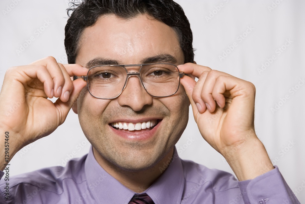 Portrait of a happy businessman trying out glasses over grey background Portrait of a happy businessman trying out glasses over grey background