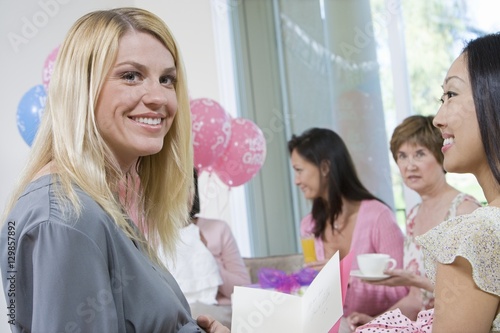 Portrait of beautiful pregnant woman with friends at a baby shower