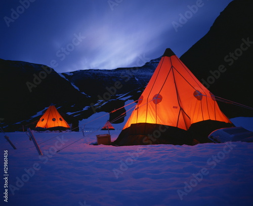 Tilley lamps light two man pyramid tents at night on the snow in Antarctica photo