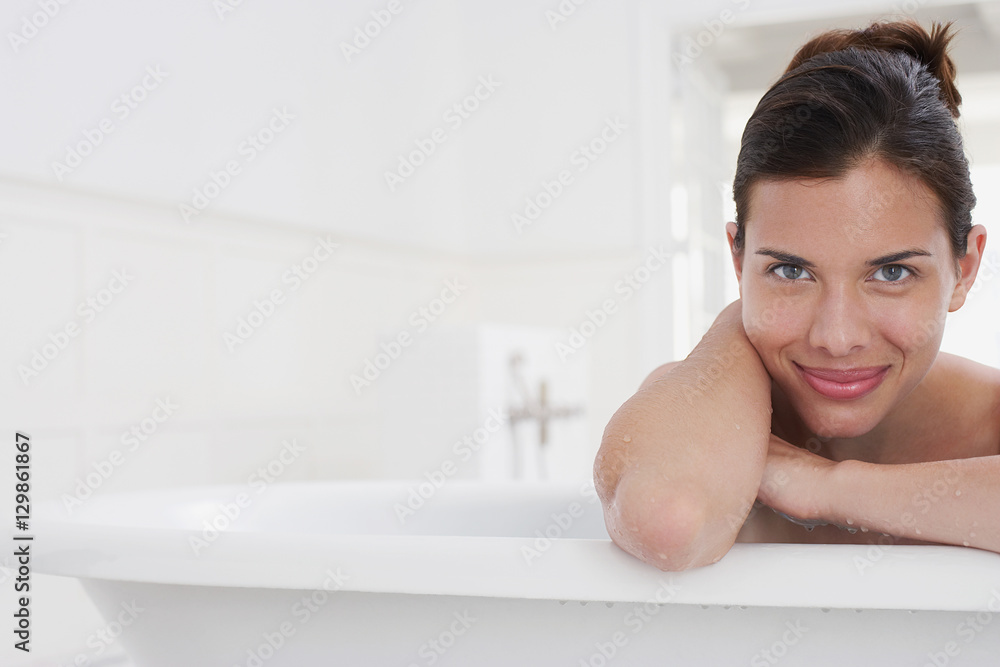 Closeup portrait of a smiling young woman relaxing in bathtub Closeup portrait of a smiling young woman relaxing in bathtub