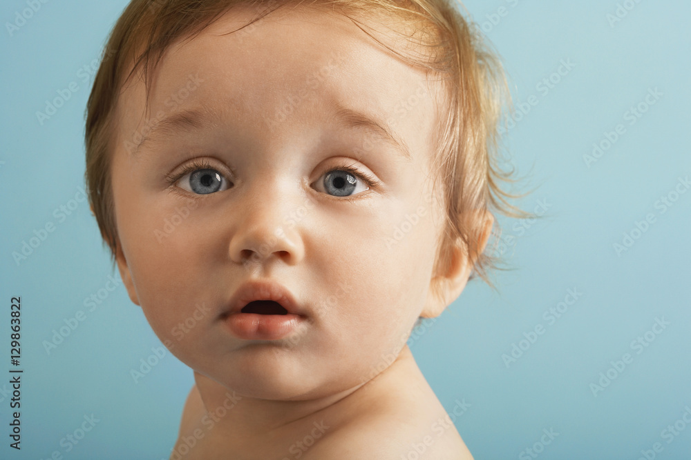 Closeup portrait of cute boy isolated on blue background Closeup portrait of cute boy isolated on blue background