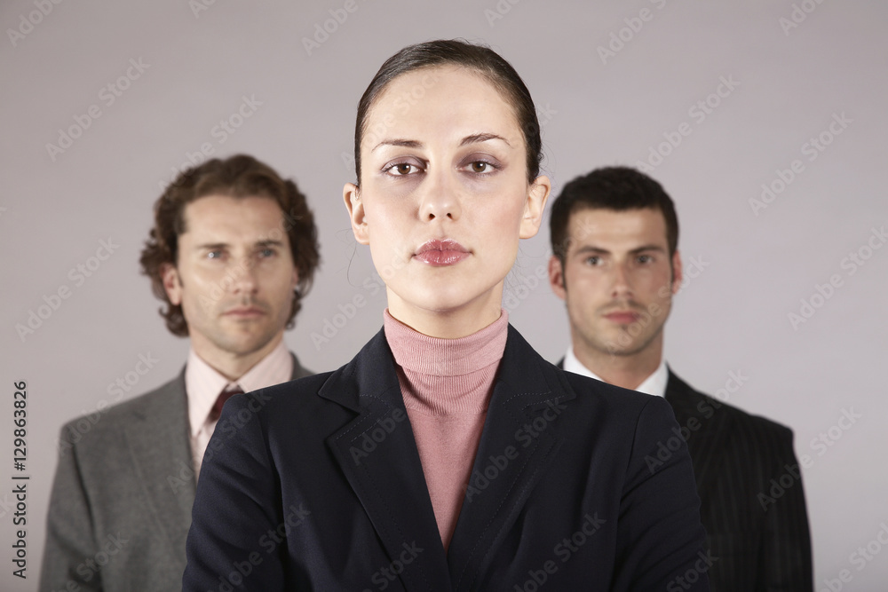 Portrait of a confident businesswoman with male colleagues in background Portrait of a confident businesswoman with male colleagues in background