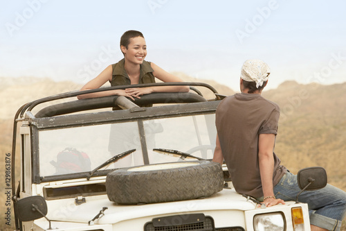 Young couple in stationary four-wheel-drive vehicle in desert © moodboard