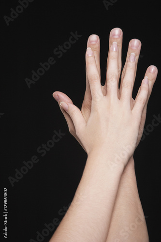 Closeup of couple hands together against black background