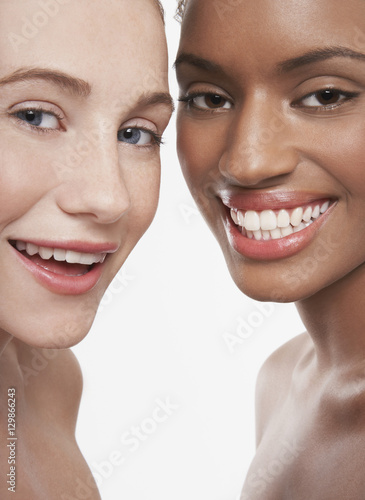 Closeup portrait of multiethnic young women smiling isolated on white background