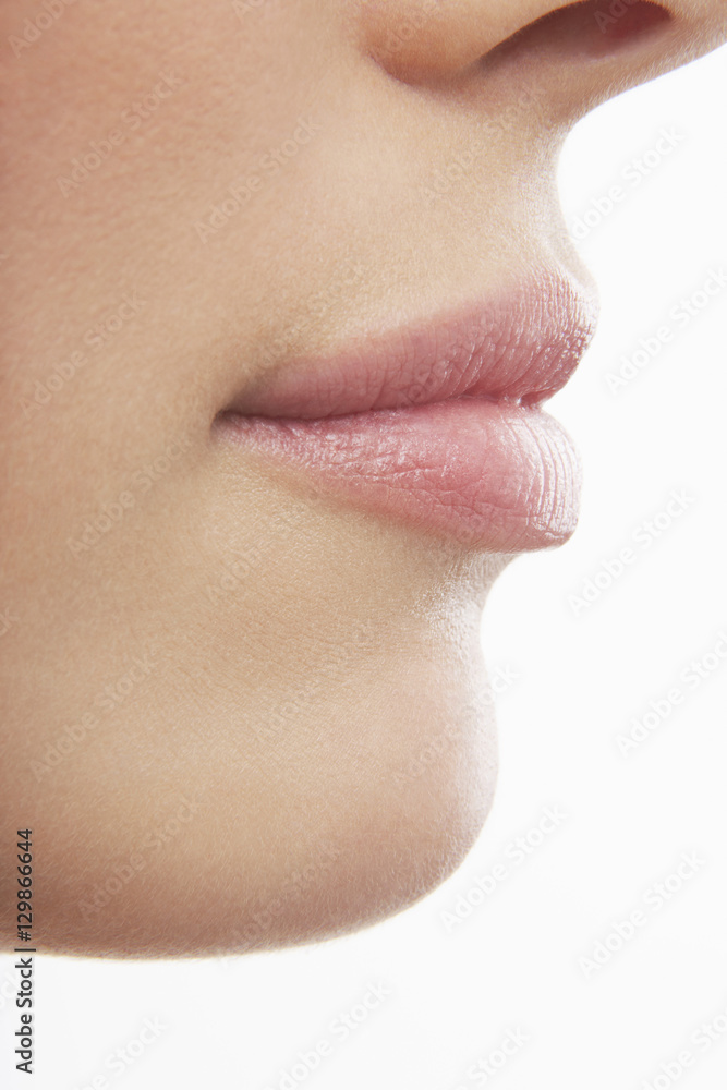 Detailed shot of young woman's lips on while background Detailed shot of young woman's lips on while background