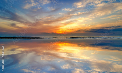 beach mirrors the sky at sunrise time