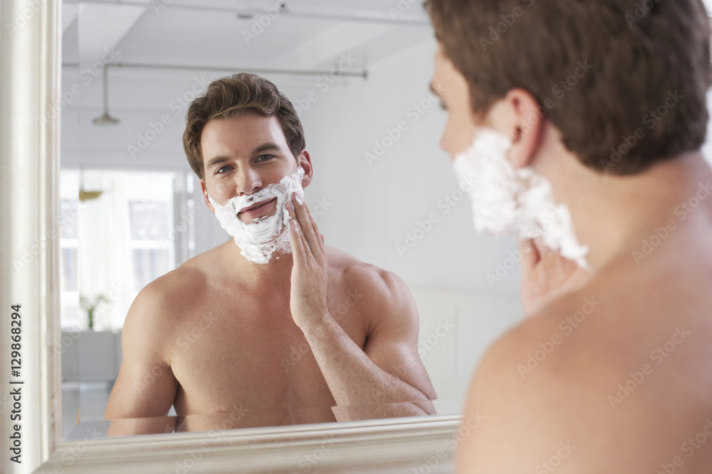 Closeup of a young man applying shaving cream