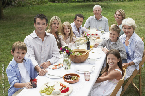 Portrait of three generation family dining together in garden