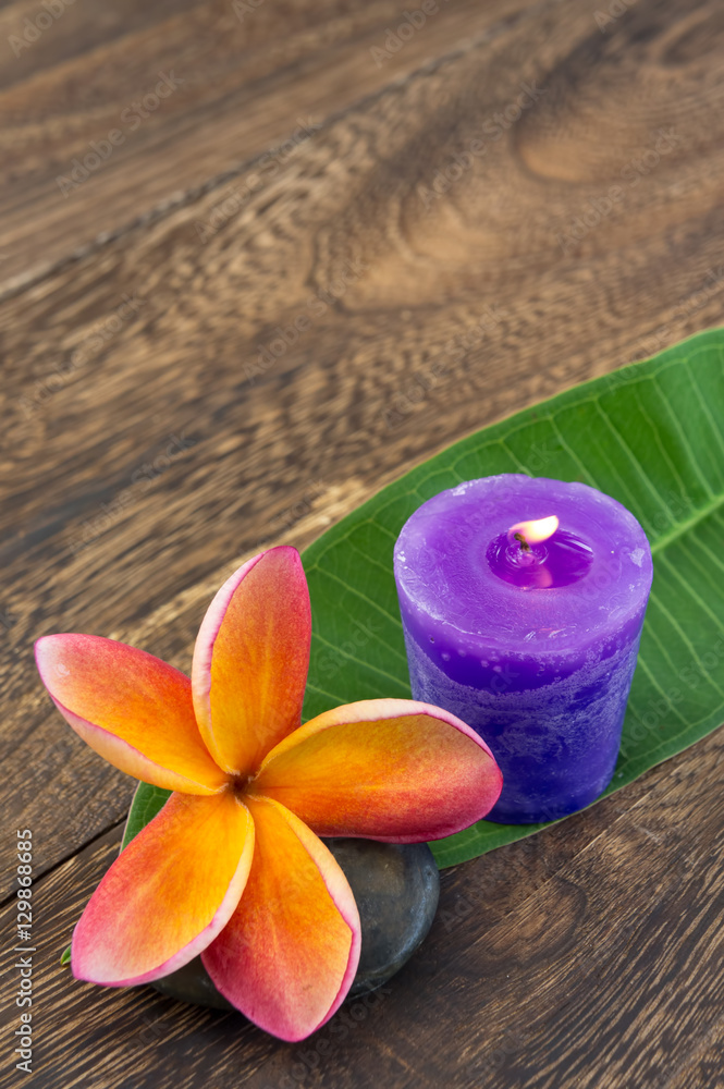 Spa concept - plumeria and candle on wooden texture