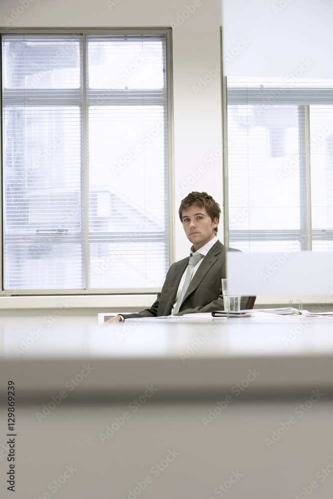 Portrait of a serious businessman sitting at desk in office Portrait of a serious businessman sitting at desk in office