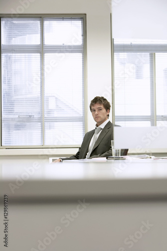 Portrait of a serious businessman sitting at desk in office