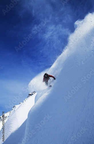 Low angle view of man snowboarding on steep slope