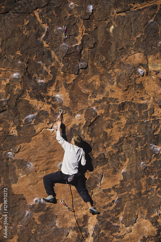 Cuadro en lienzo Rear view of rock climber climbing up a cliff