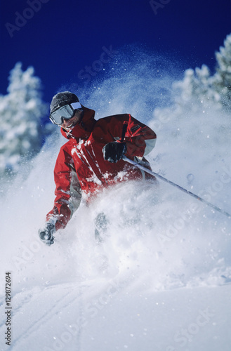 Skier skiing in powder snow against clear sky