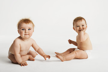 Full length of cute babies sitting isolated on white background