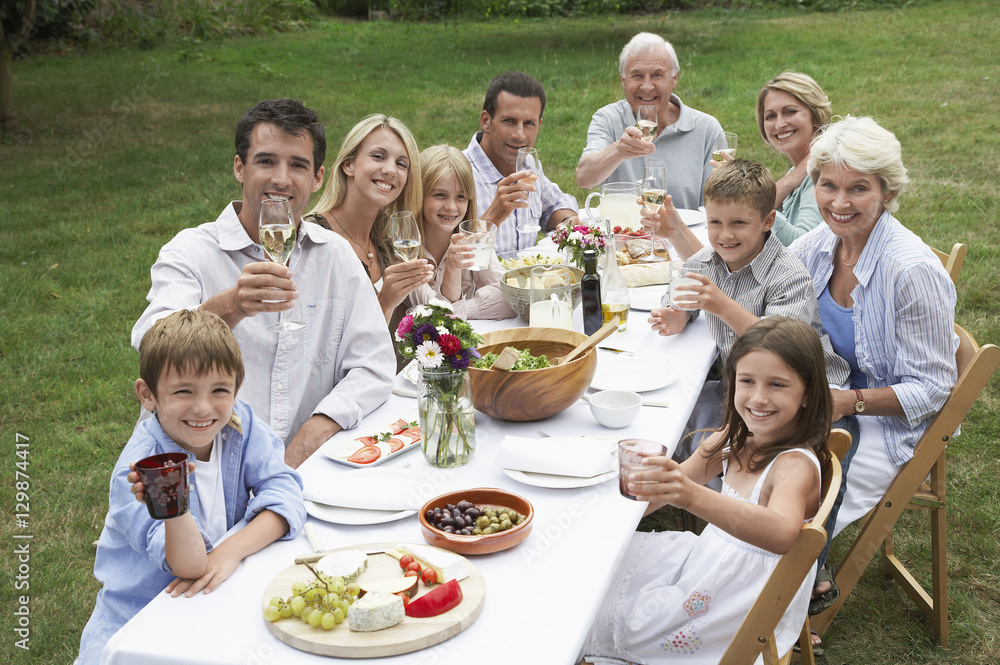 Portrait of three generation family dining together in garden