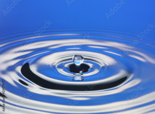 Drop hitting surface of water close-up